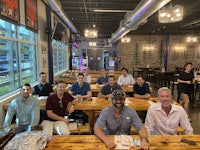 a group of men sitting at a table in a restaurant